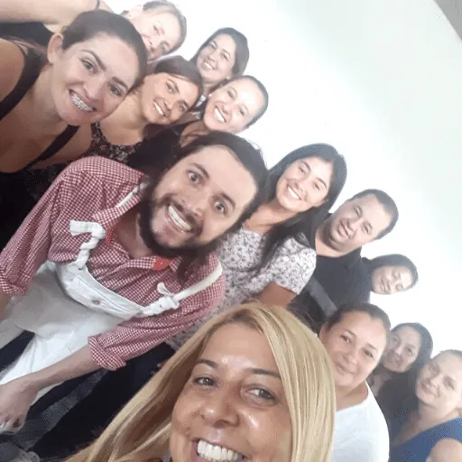 Turma de professoras e professor sorrindo em selfie